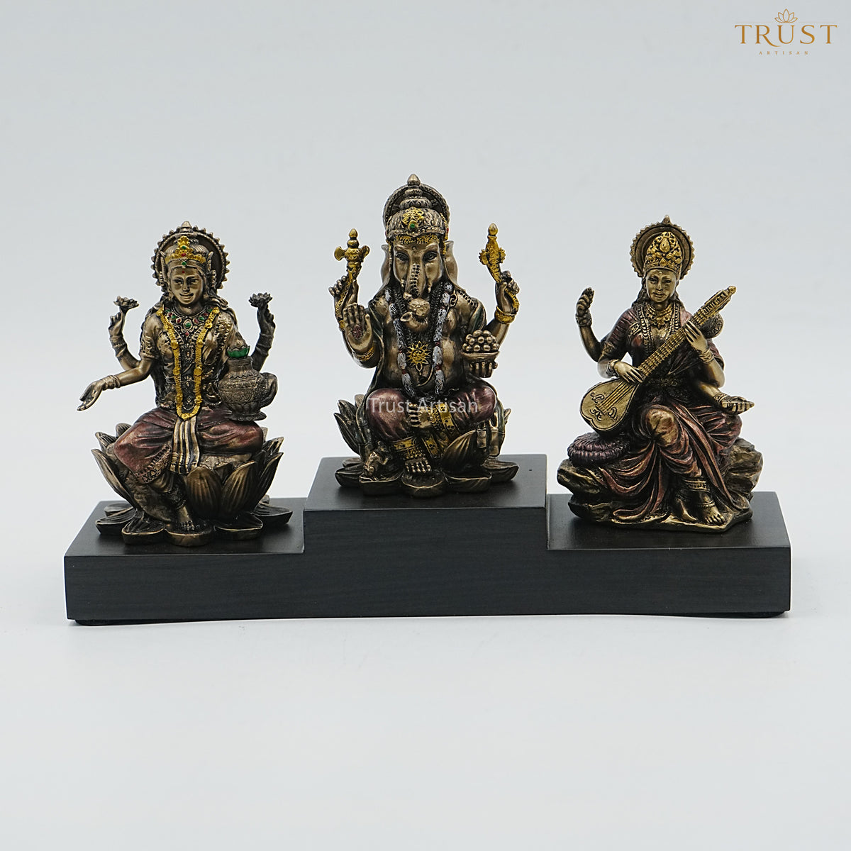 Handcrafted Resin Laxmi Ganesh Saraswati Idol Set – Seated Trio on Tiered Wooden Base, Antique Bronze Finish for Home Temple & Diwali Pooja